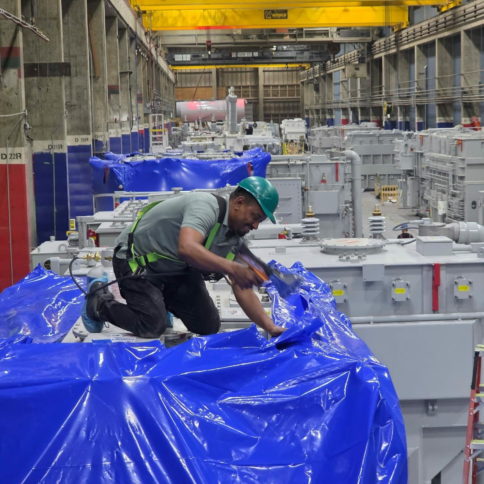 Large power transformer fully sealed in blue heat shrink wrap with white reinforcement banding