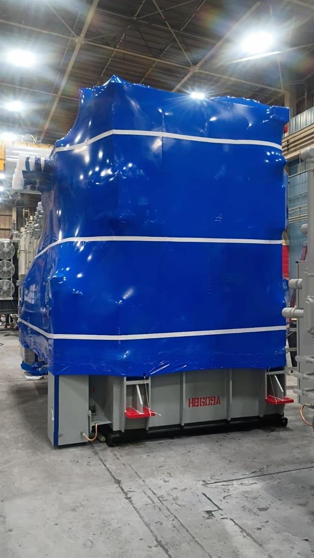 Tall power transformer preserved in shrink wrap for storage